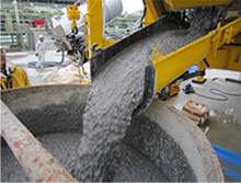 Geopolymer concrete being formed at an engineering site from a revolving drum-type mixer